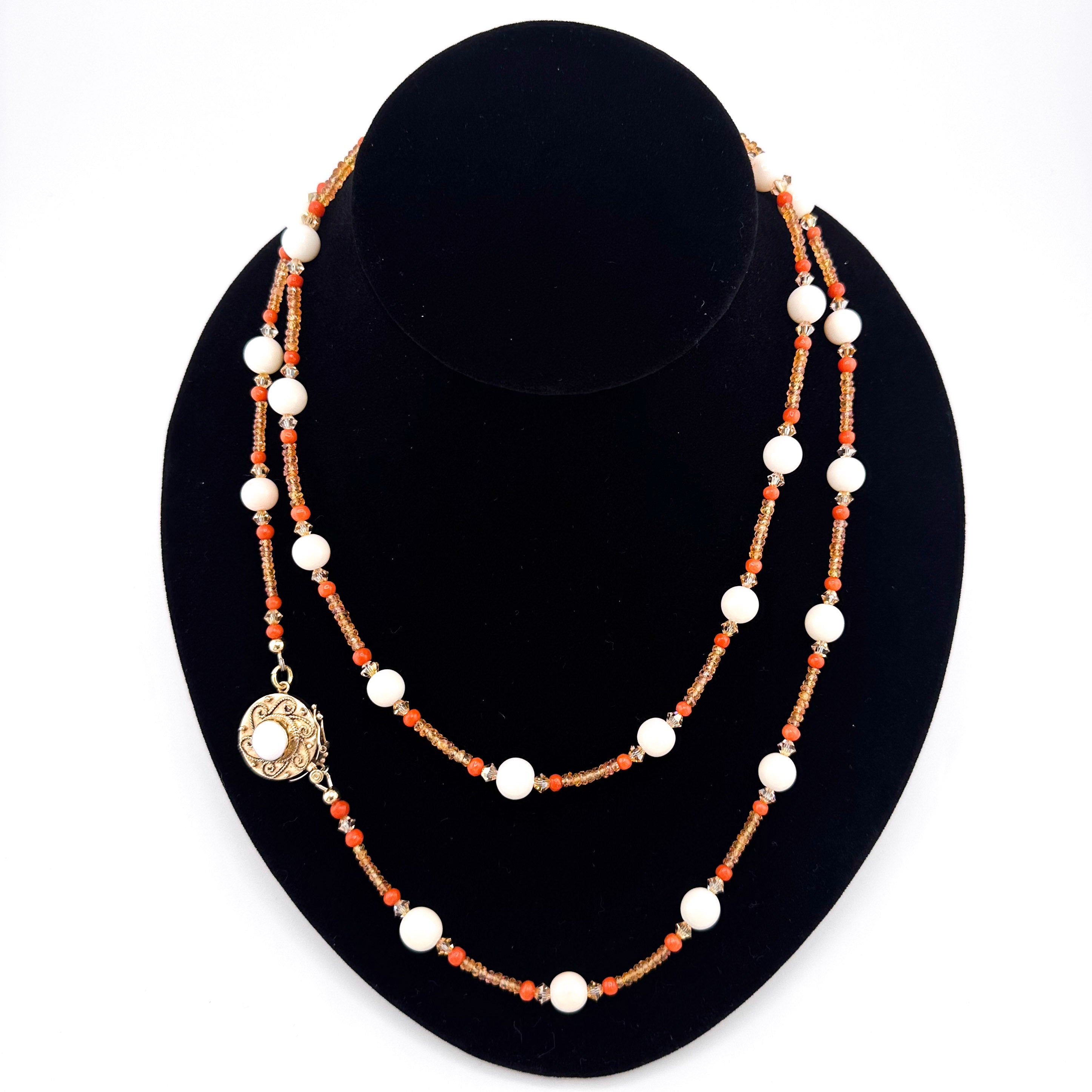 Angel Skin Coral, Sapphire, Coral, Swarovski Crystal, and 14K Gold Necklace on black bust