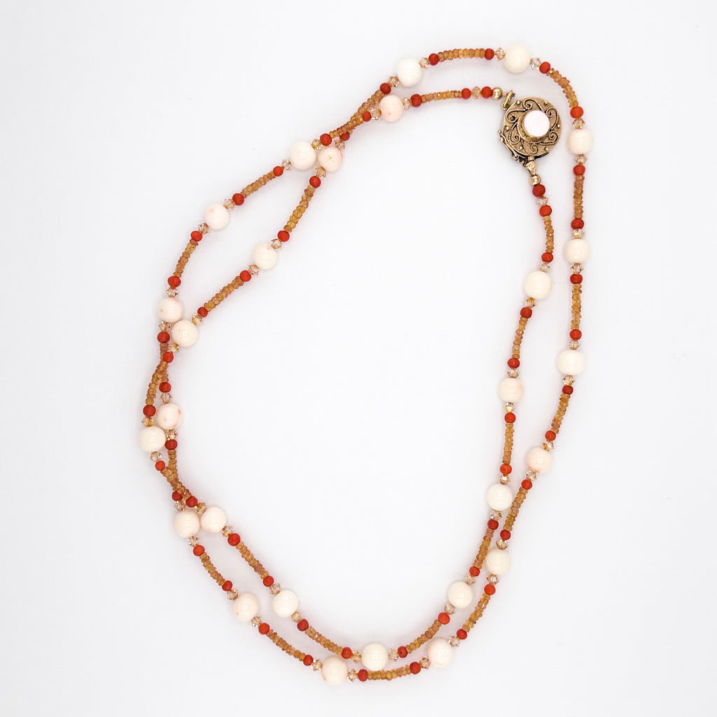 Angel Skin Coral, Sapphire, Coral, Swarovski Crystal, and 14K Gold Necklace flatlay on white background