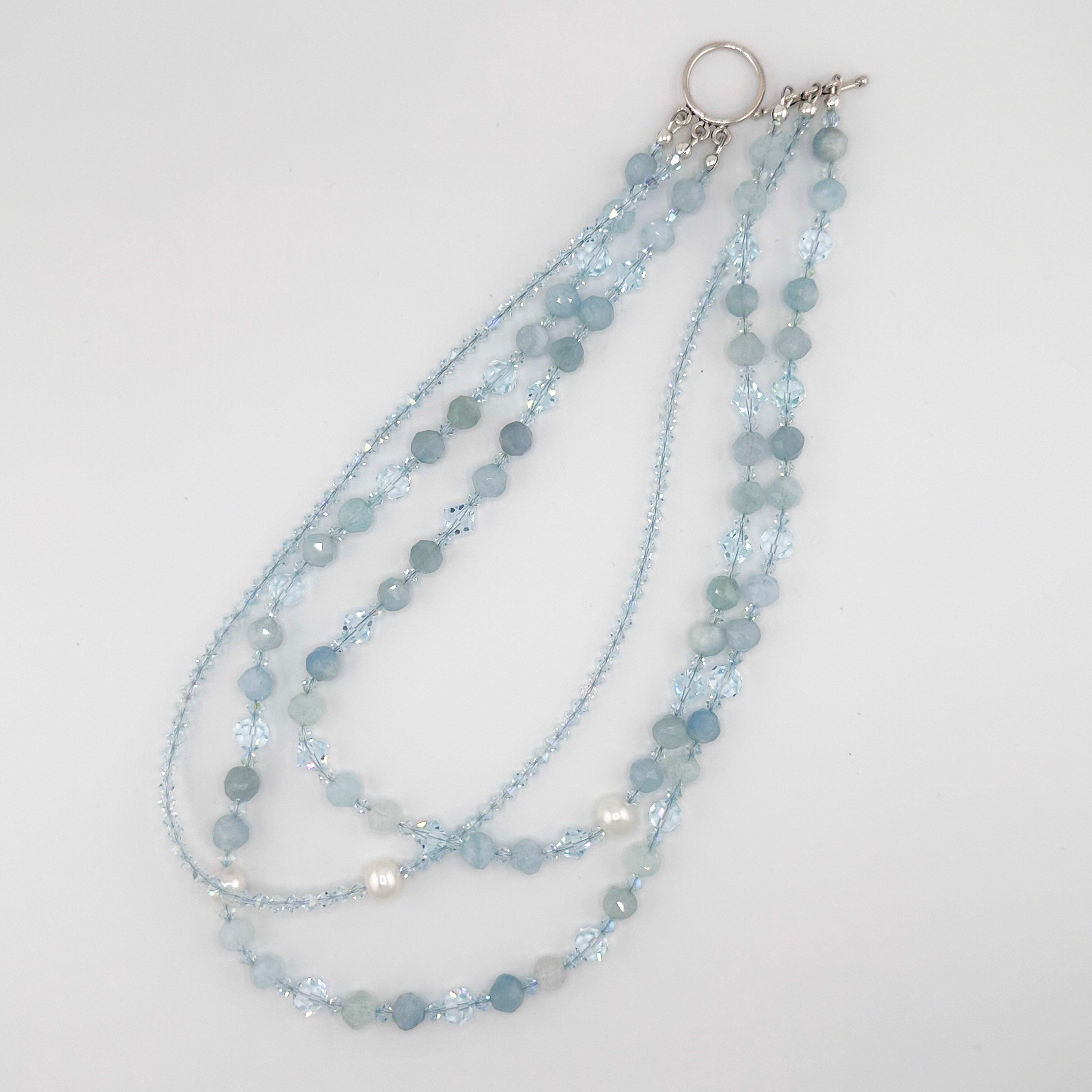 Aquamarine, Pearl, Swarovski Crystal, and Sterling Silver Necklace flatlay on white background