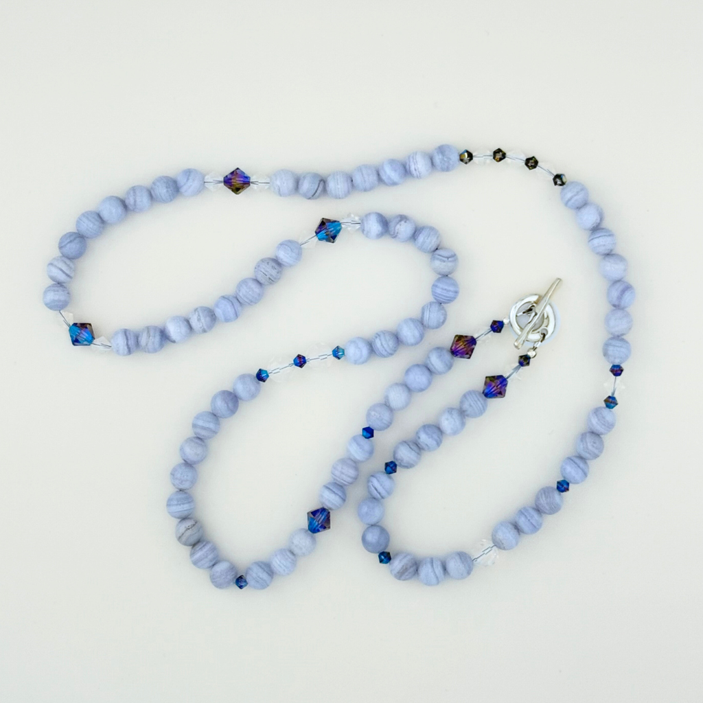 Blue Lace Agate, Swarovski Crystal, and Sterling Silver Necklace close-up on white background