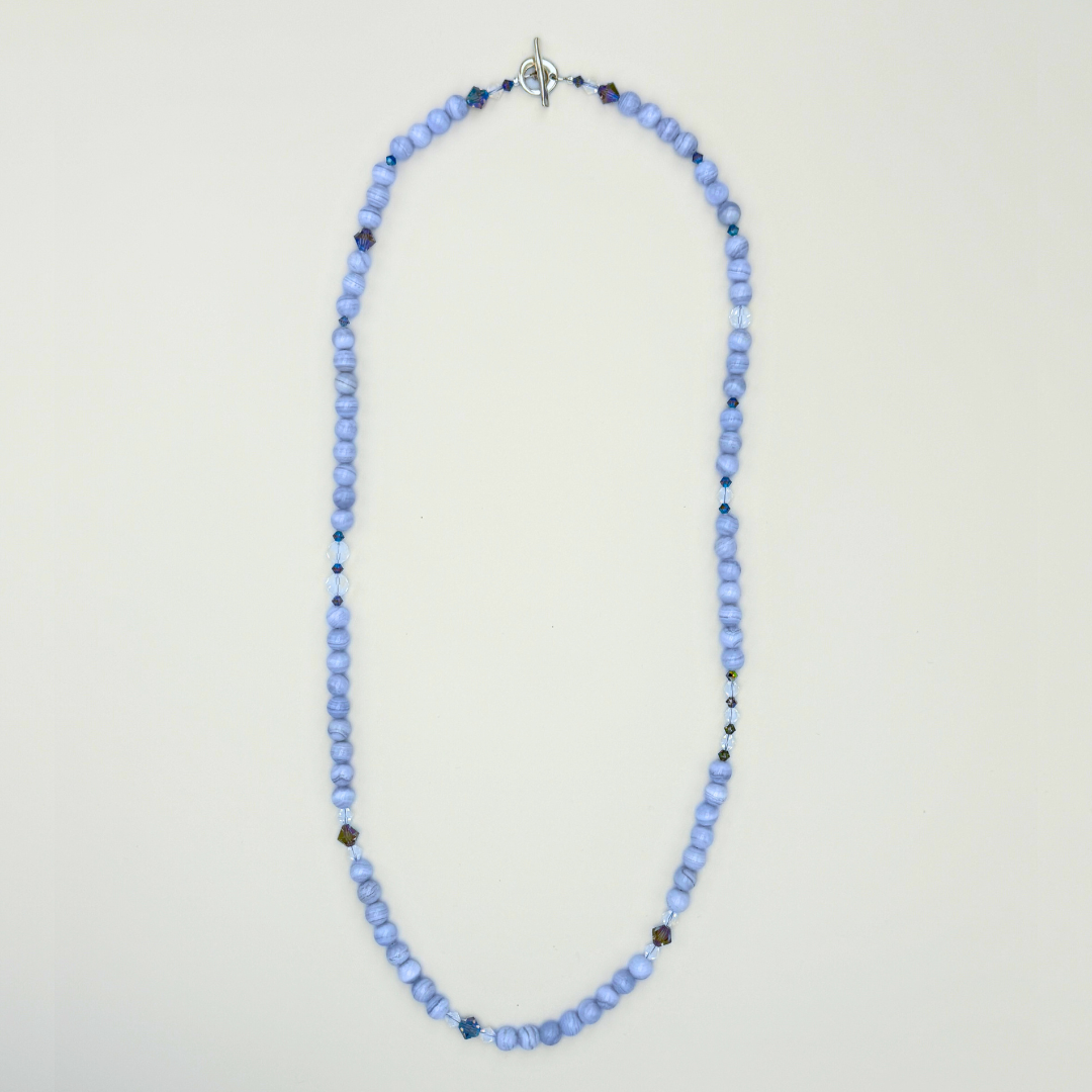 Blue Lace Agate, Swarovski Crystal, and Sterling Silver Necklace flatlay on white background