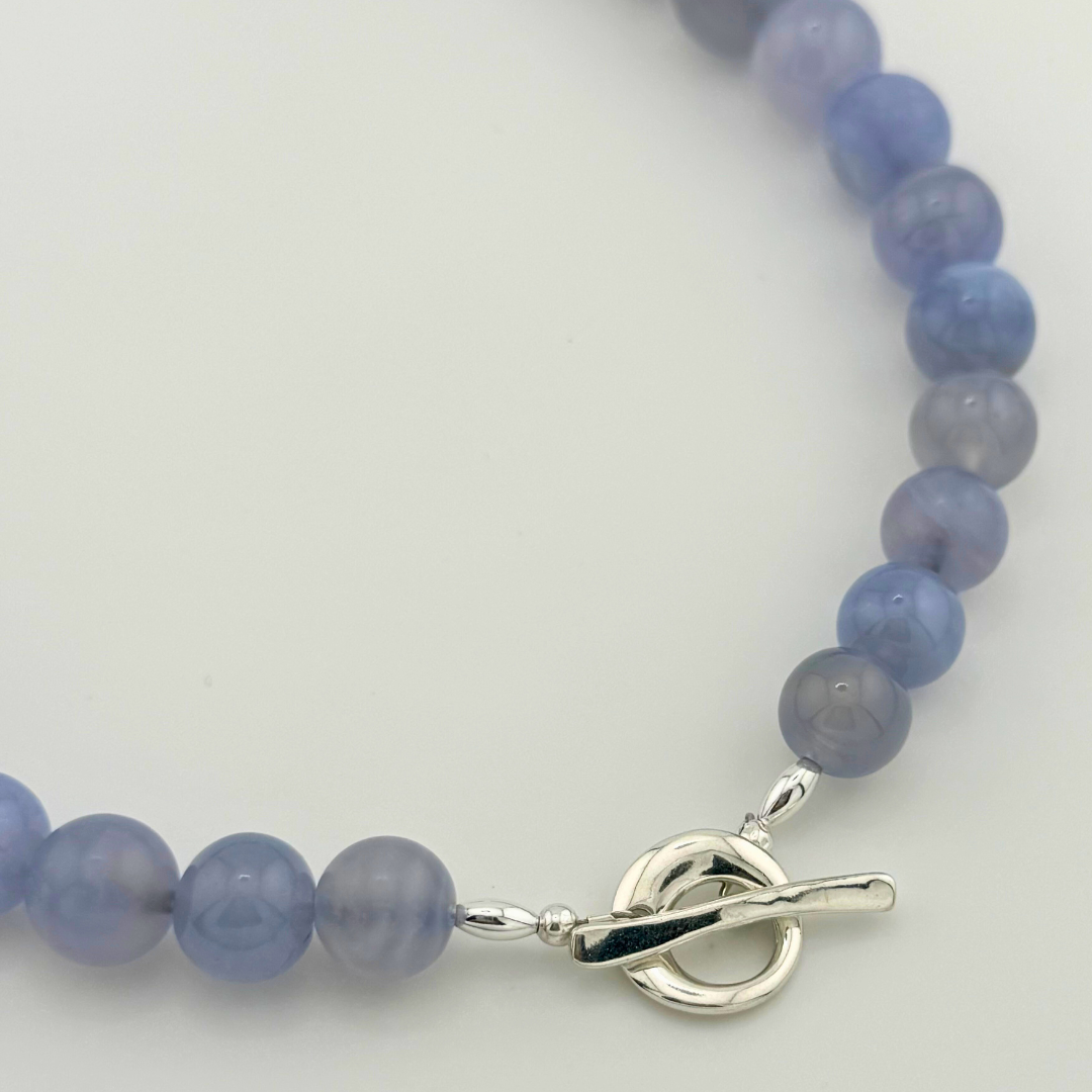 Blue Lace Agate, Swarovski Crystal, and Sterling Silver Necklace close-up on white background