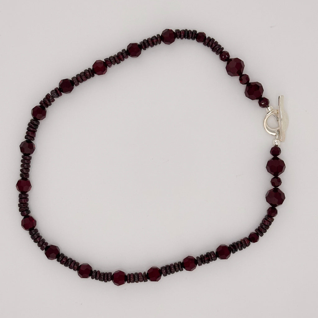 Garnet, Swarovski Crystal, and Sterling Silver Necklace flatlay on white background