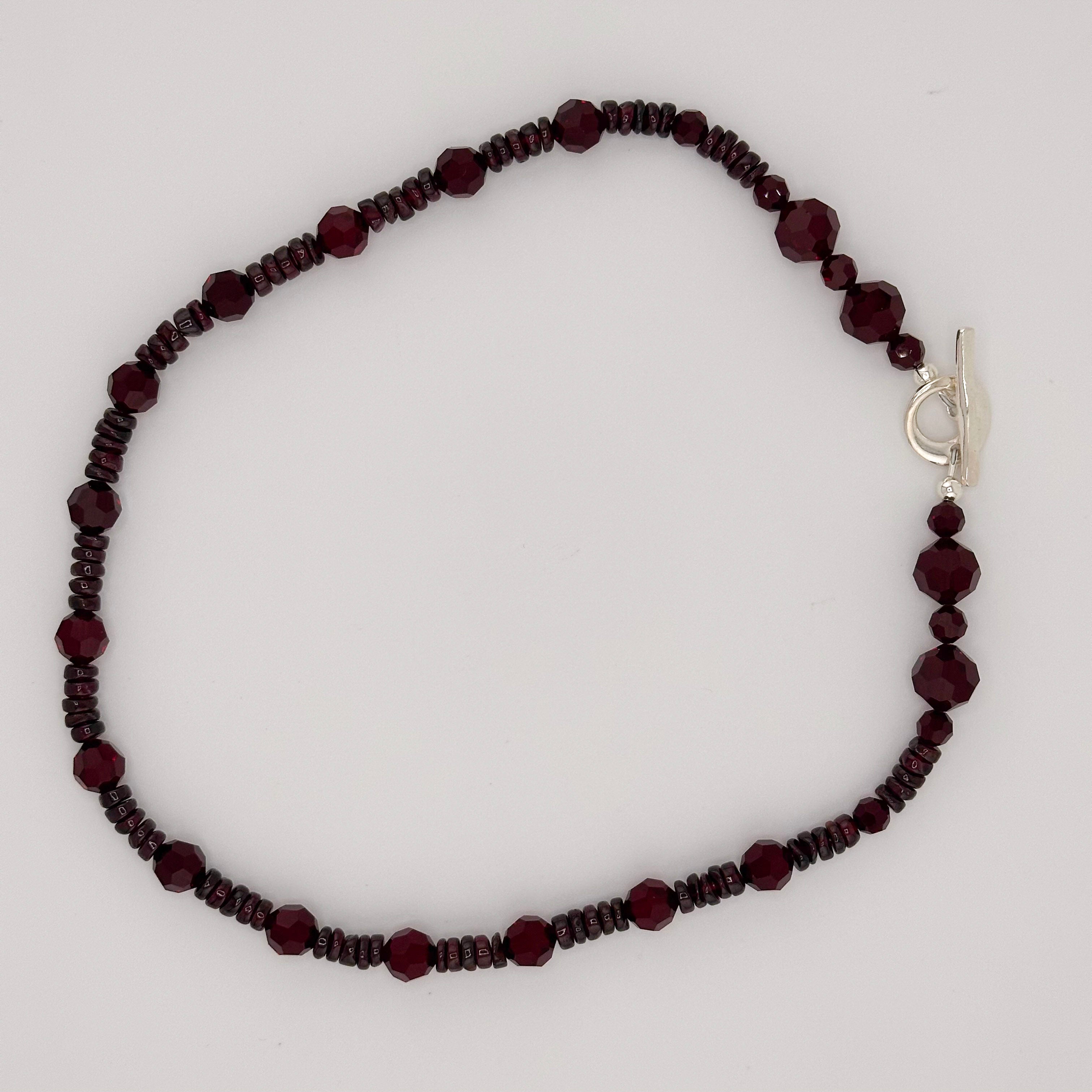 Garnet, Swarovski Crystal, and Sterling Silver Necklace flatlay on white background