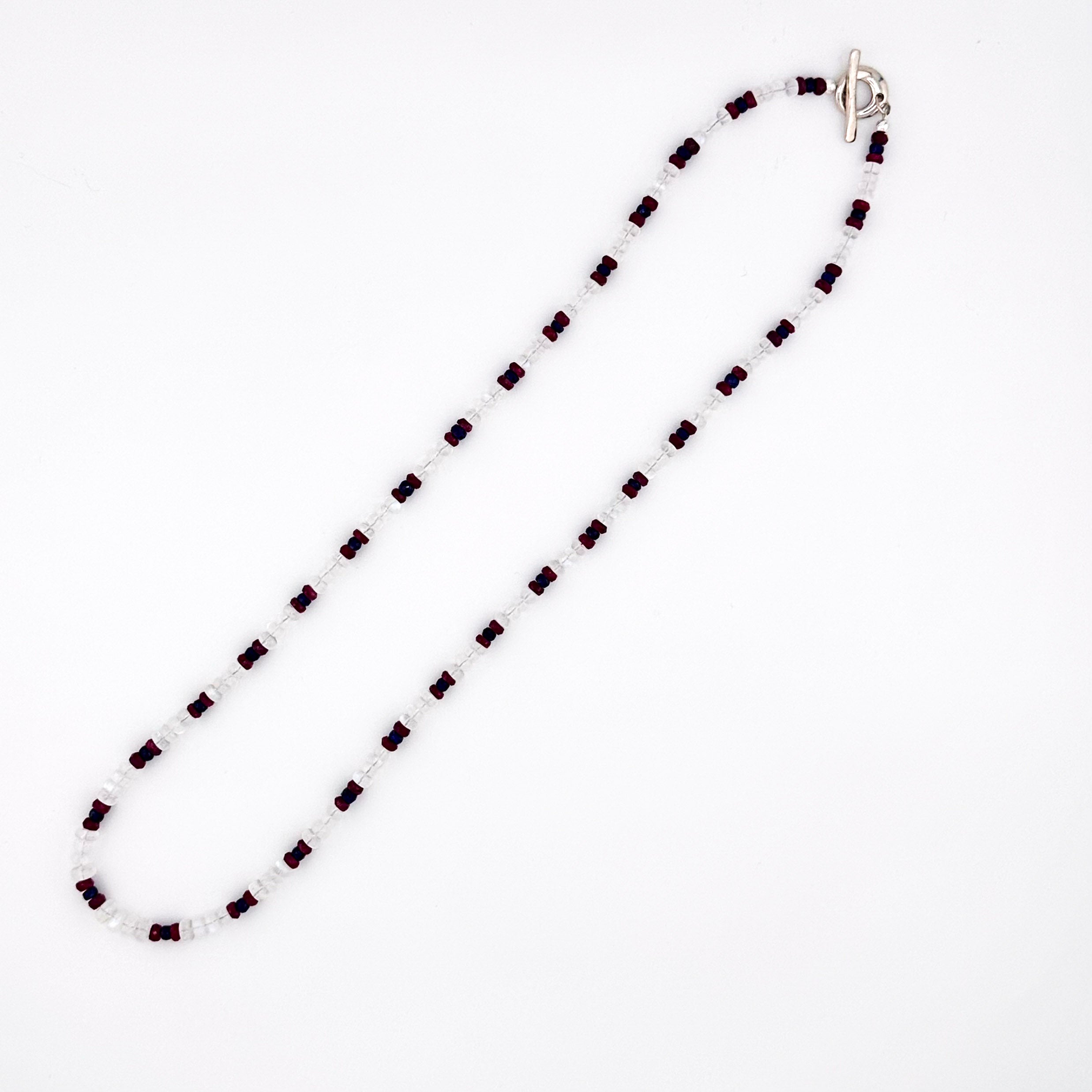 Moonstone, Ruby, Sapphire, and Sterling Silver Necklace flatlay on white background