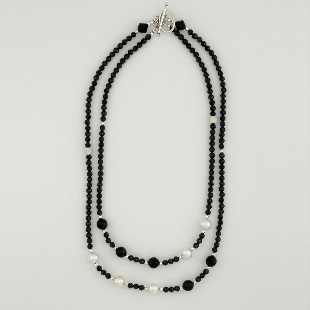 Pearl, Spinel, Onyx, and Sterling Silver flatlay on white background