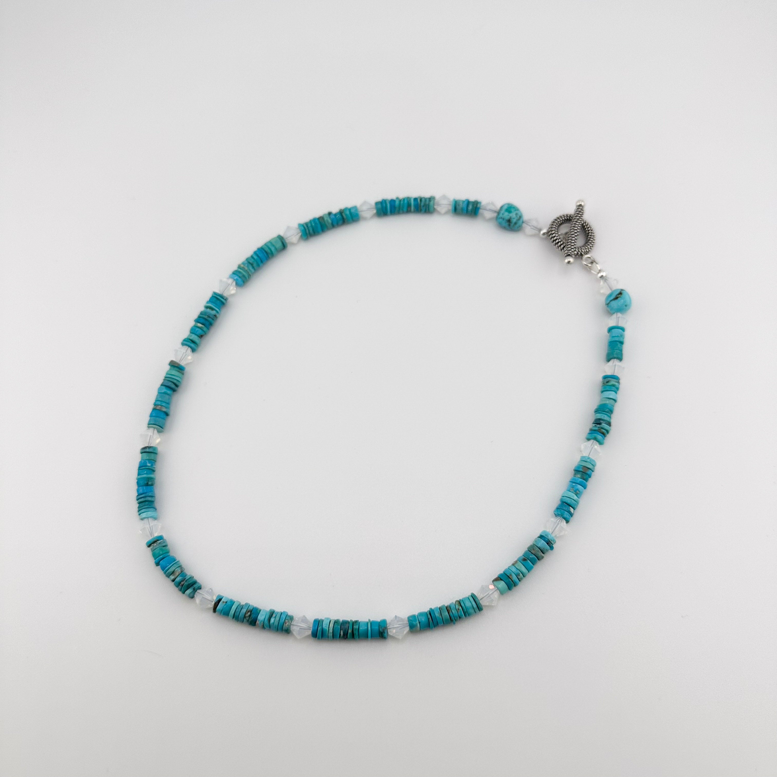 Turquoise, Swarovski Crystal, and Sterling Silver Necklace flatlay on white background