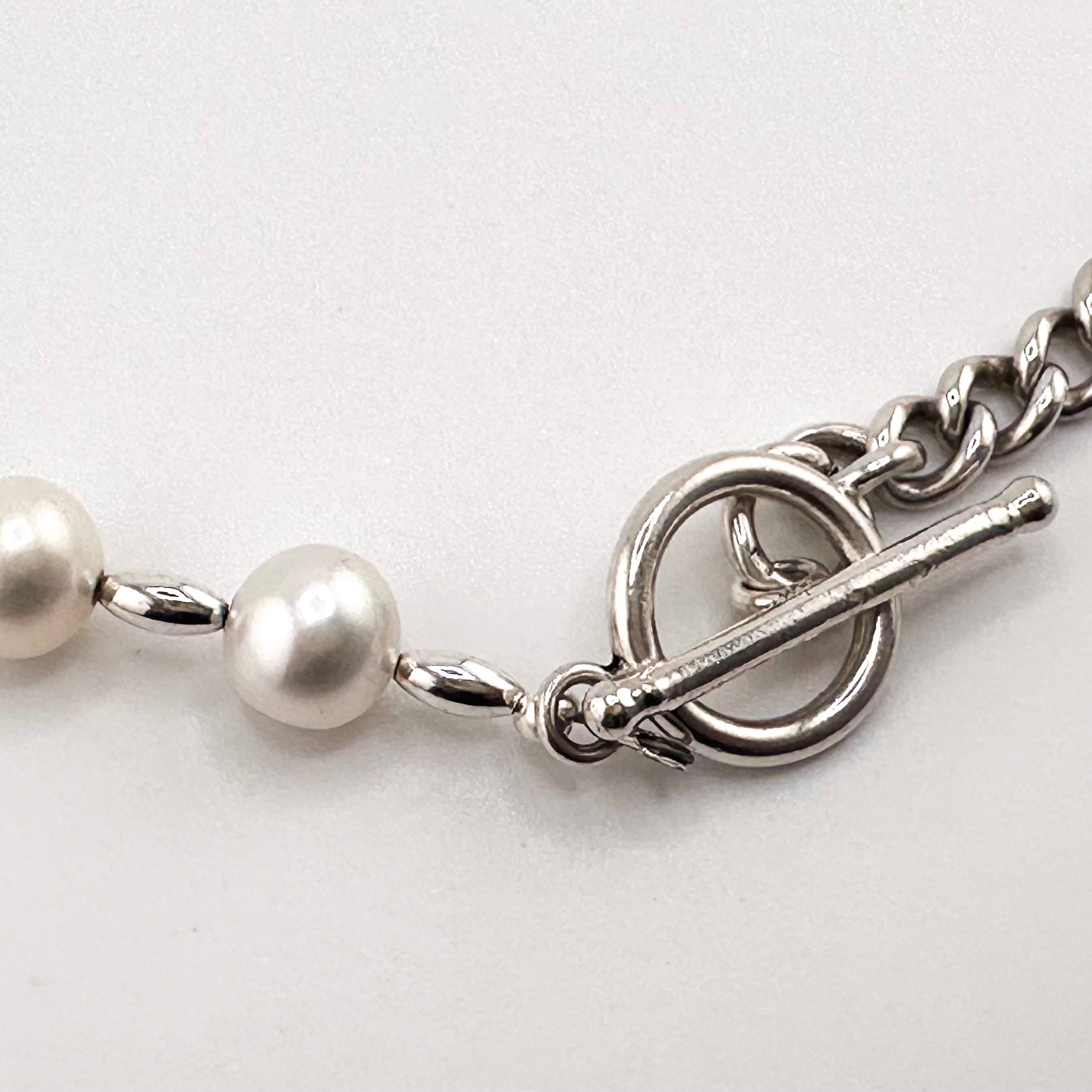 Sterling Silver Watch Chain and Pearls Necklace close-up on white background