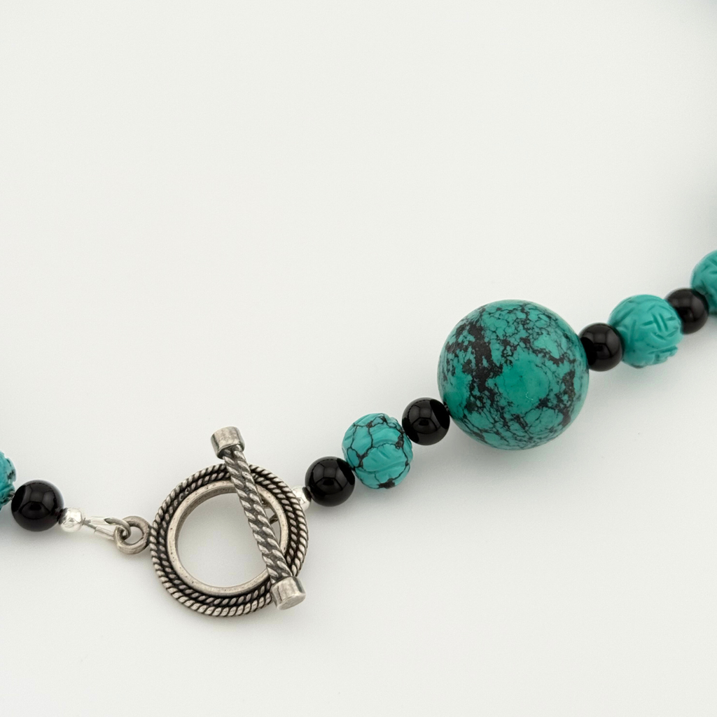 Turquoise, Onyx, and Silver Necklace clasp detail on white background